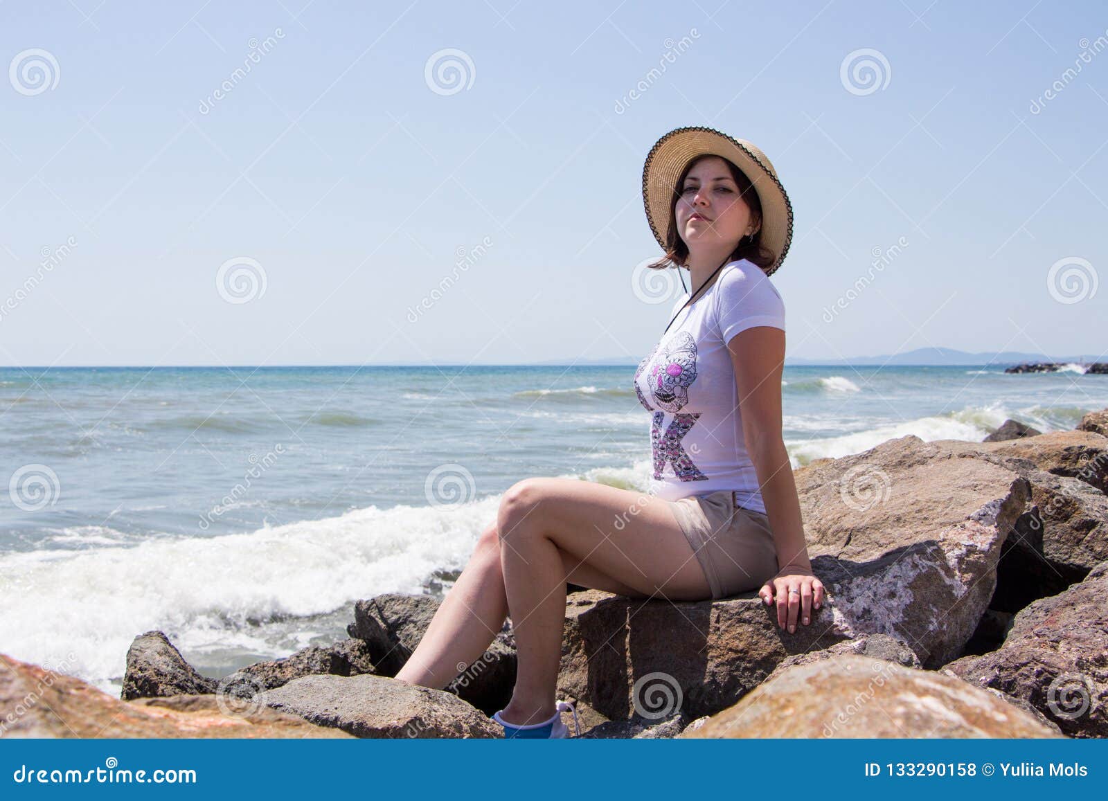 Young Beautiful Woman in the Hat Sitting on the Rock by the Sea Stock ...