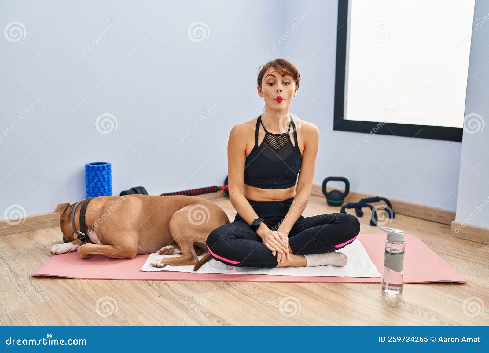 Young Beautiful Woman Sitting on Yoga Mat Making Fish Face with