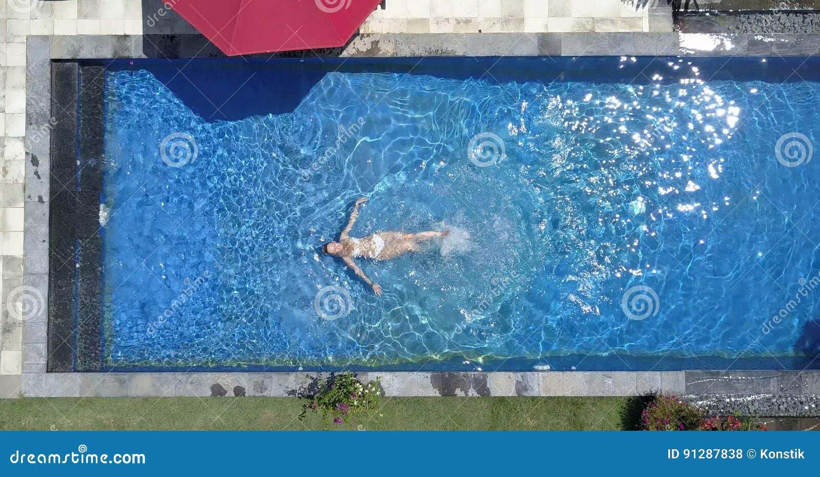 the young beautiful woman swims in the pool, flat lay, dron view