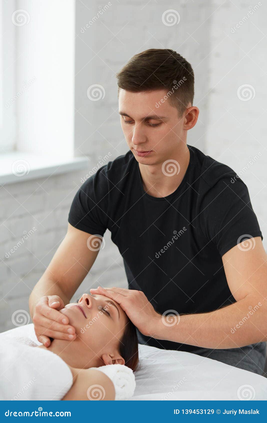 Professional Massage Therapist Is Treating A Female Patient In