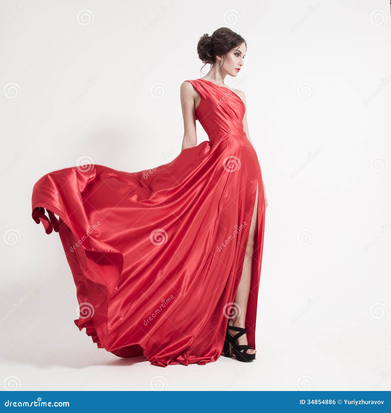 young beauty woman in fluttering red dress. white background.