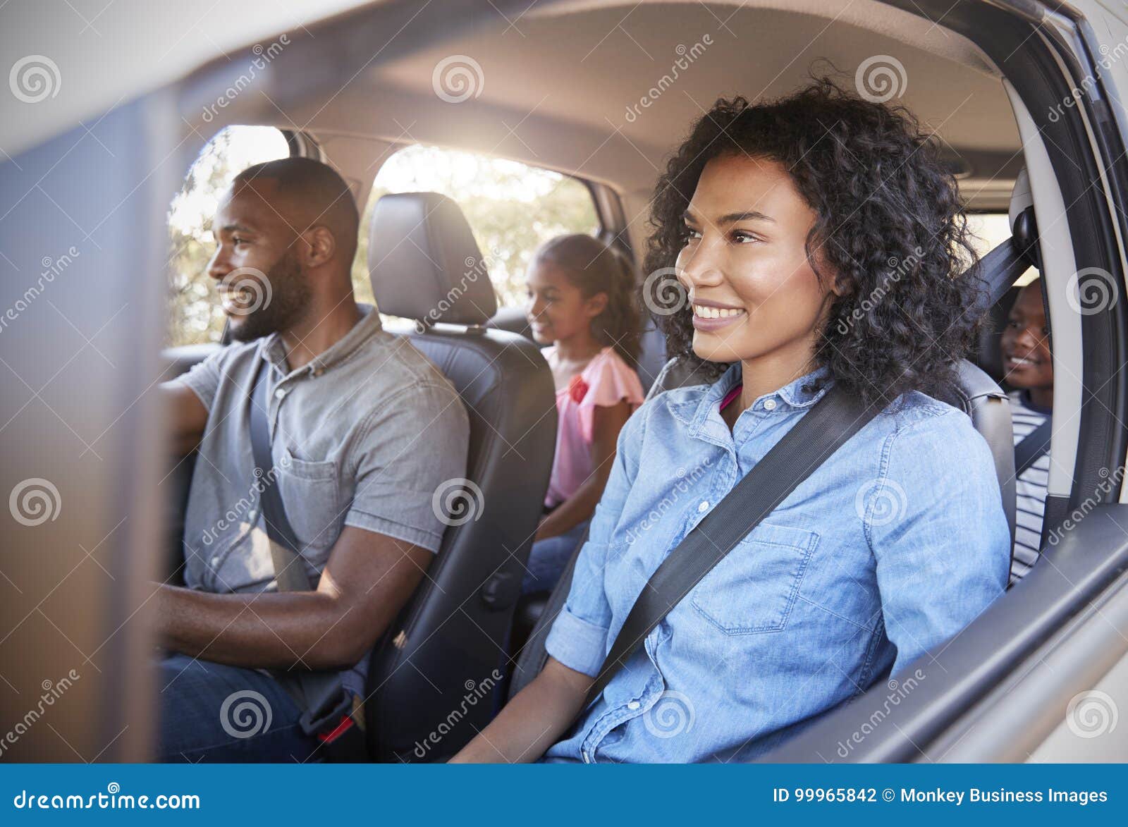 young black family with children in a car going on road trip
