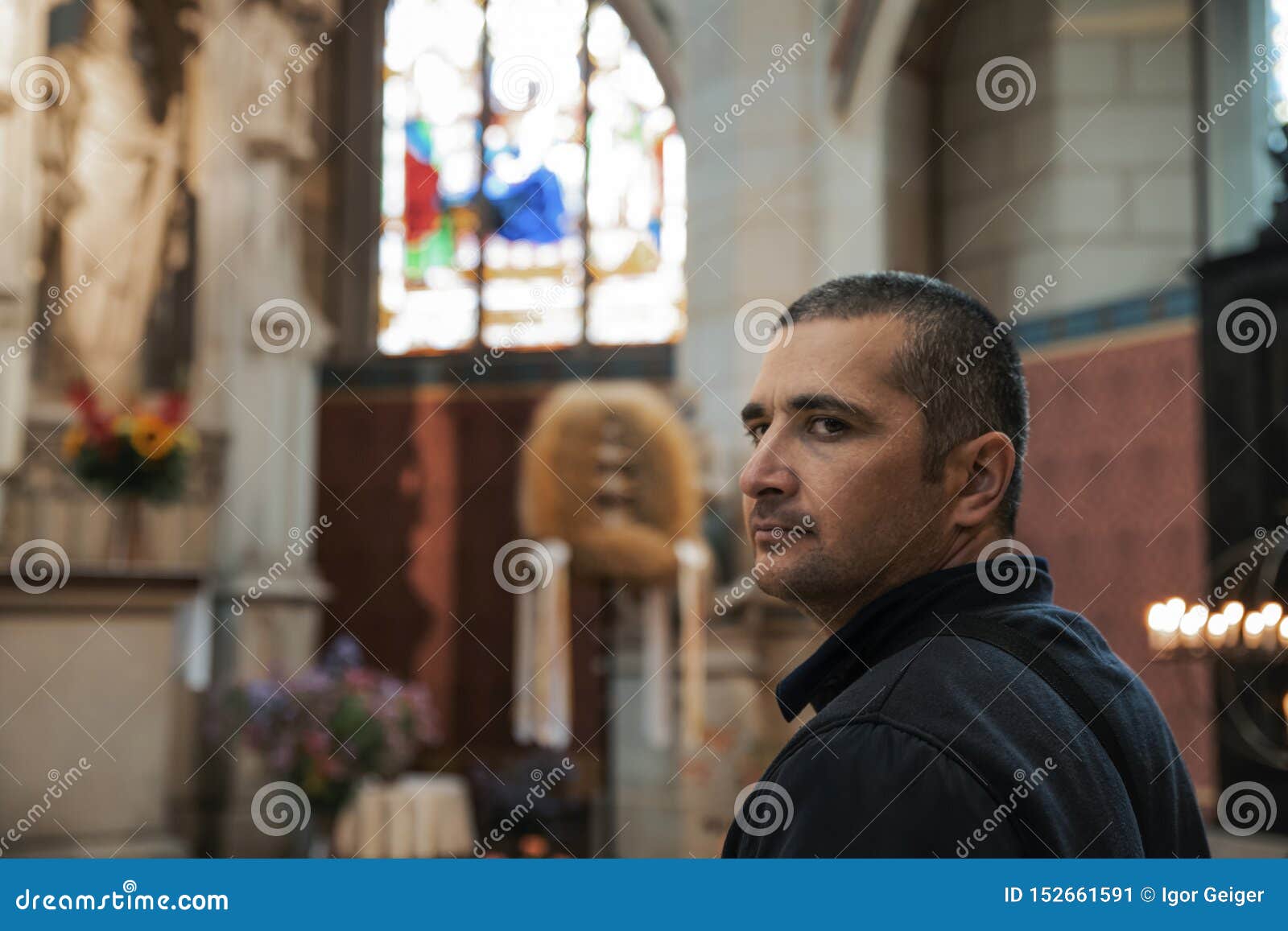young black-haired man in a catholic church enthusiastically sights