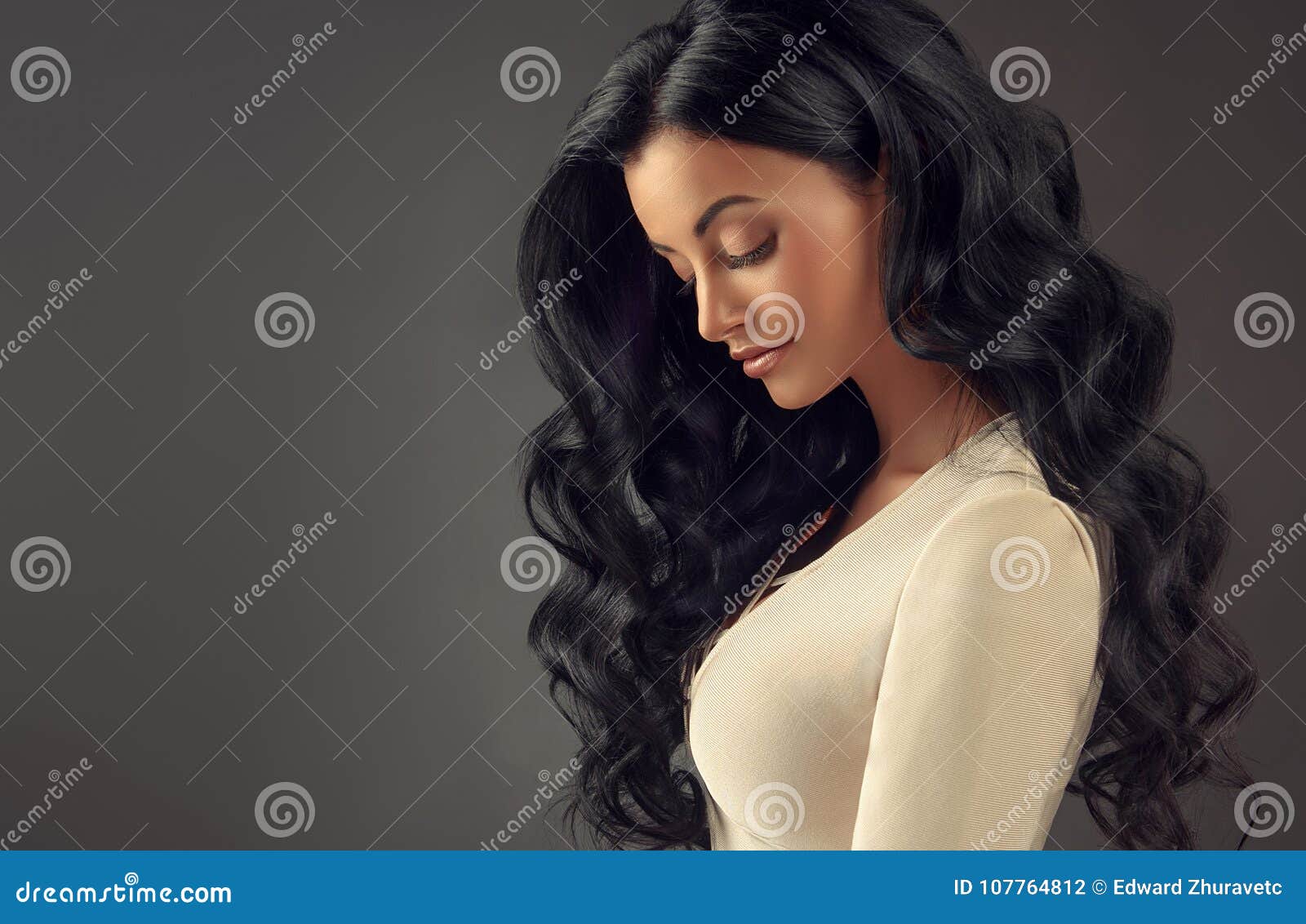 young black haired woman with voluminous, shiny and wavy hair.