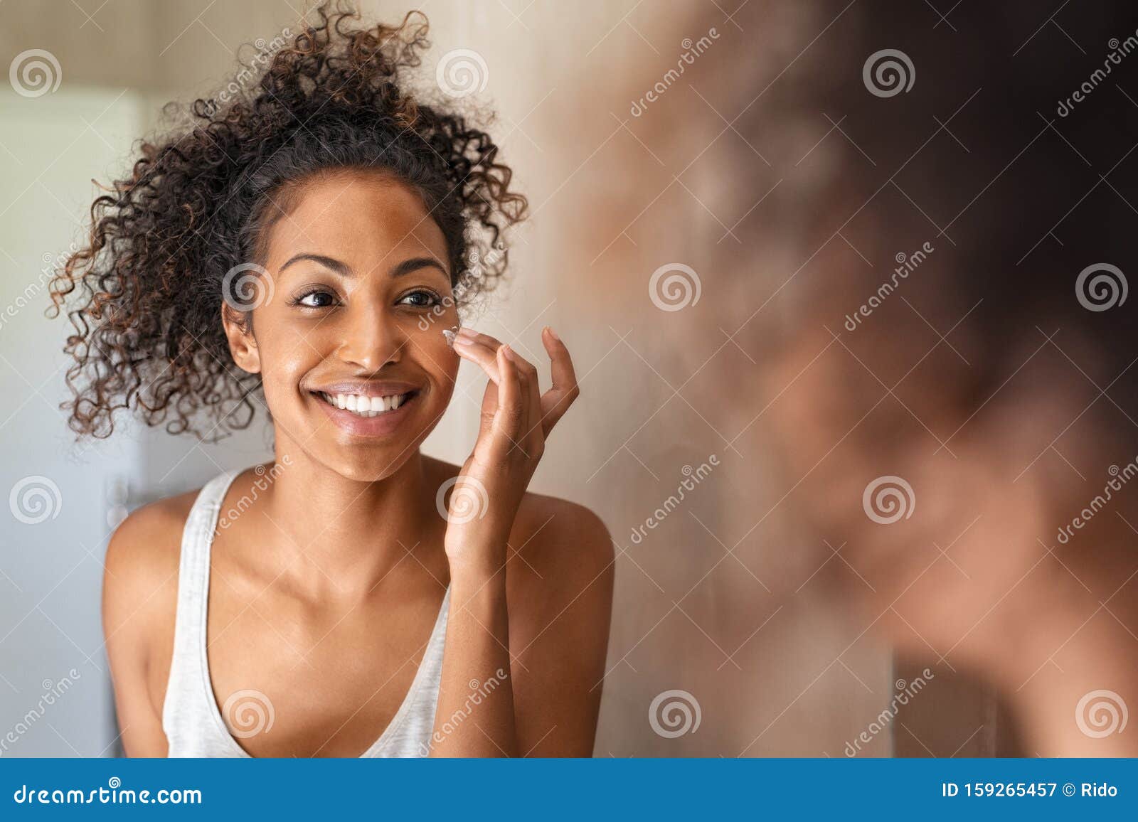 young black woman applying skin cream