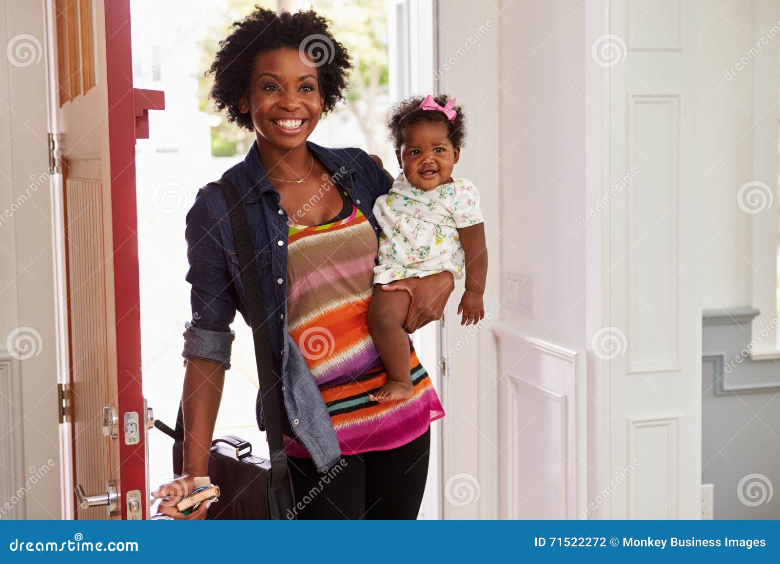 young black woman holding child arriving home