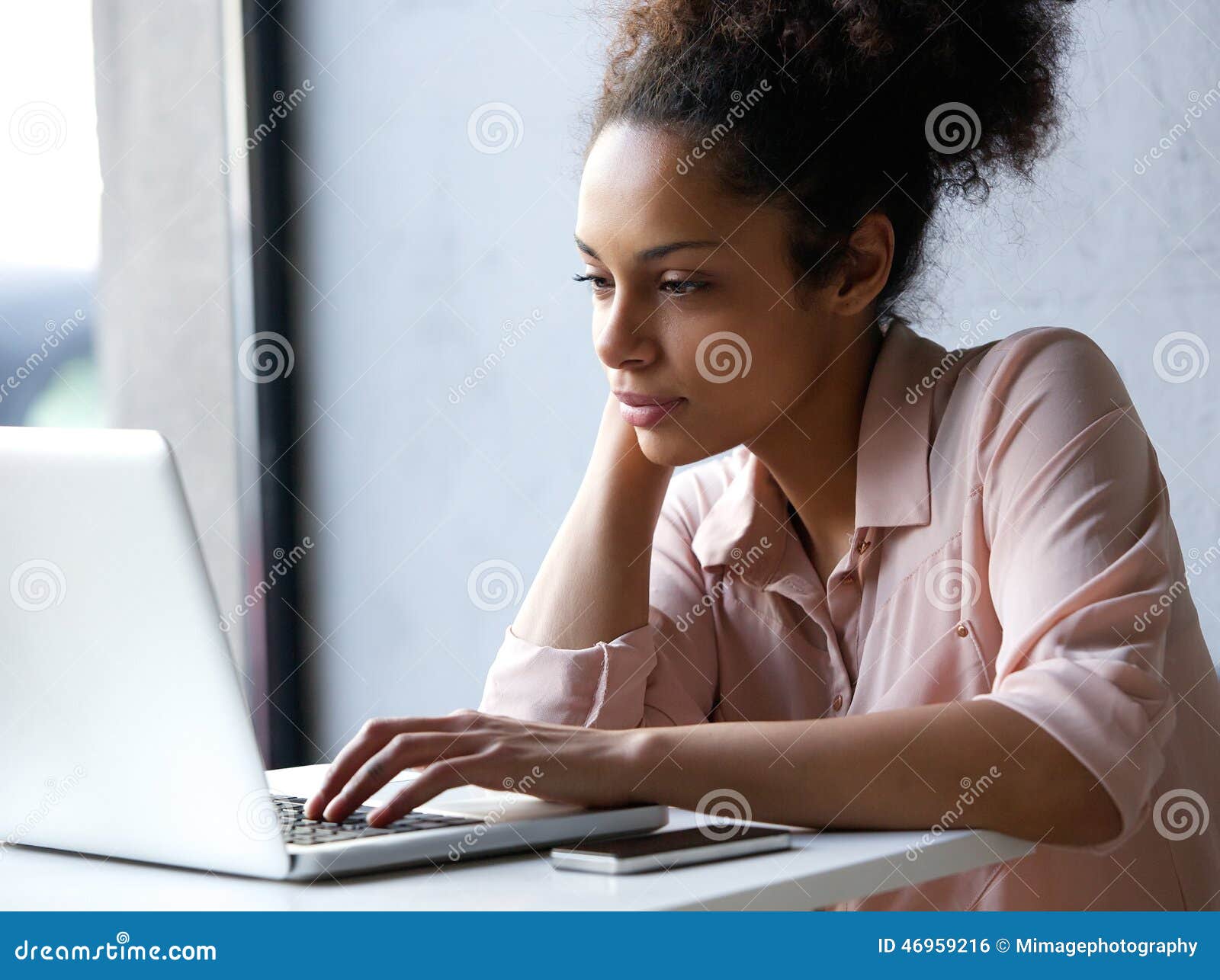 young black woman looking at laptop