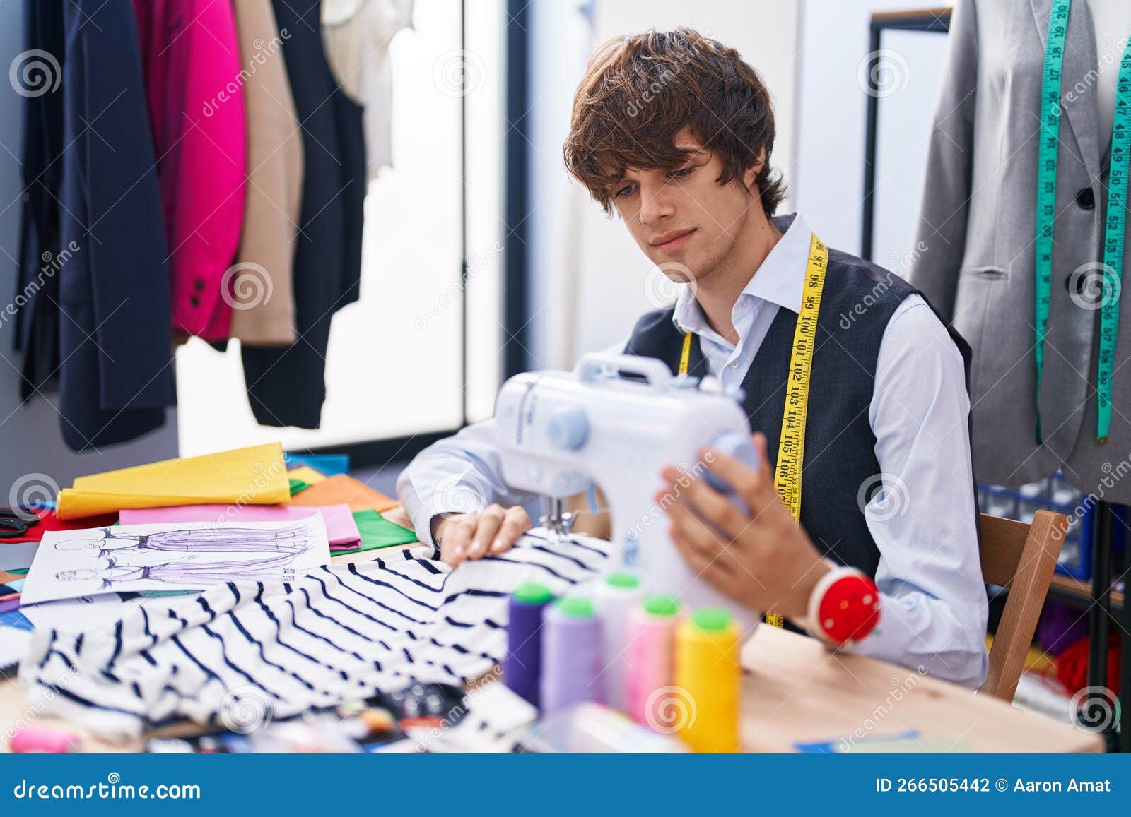 Young Blond Man Tailor Using Sewing Machine at Clothing Factory Stock