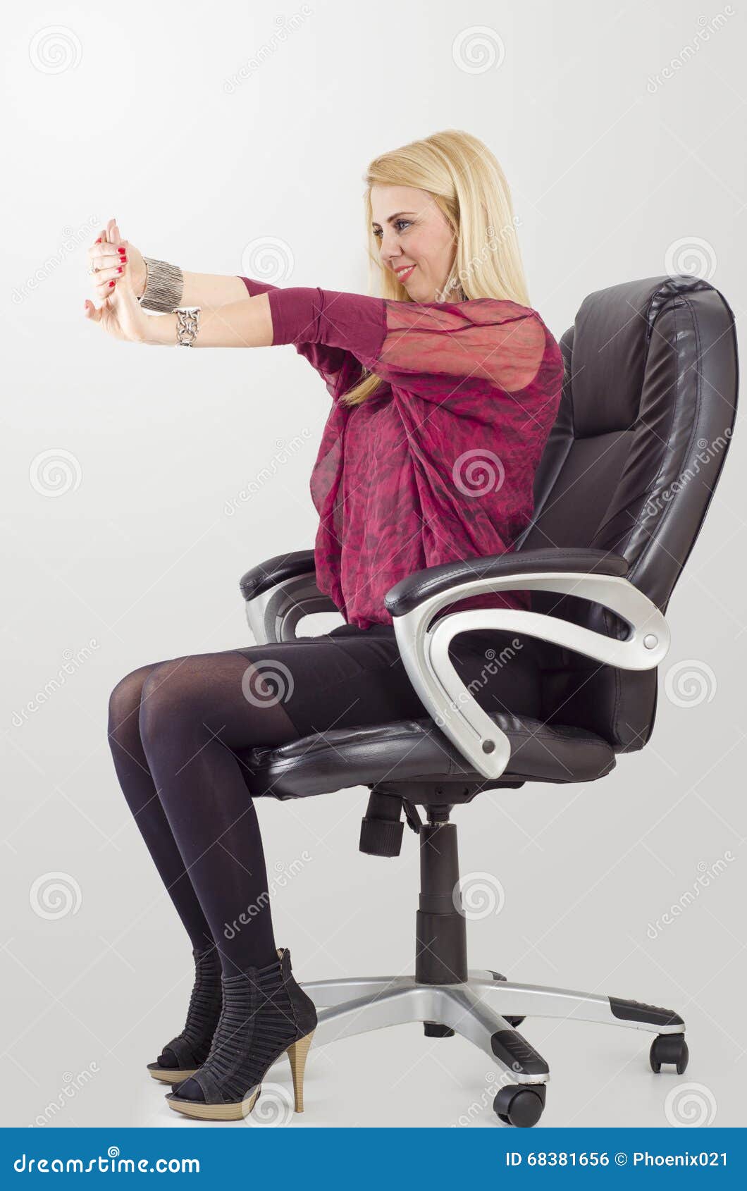 Young Blonde Businesswoman Doing Stretching While Sitting In