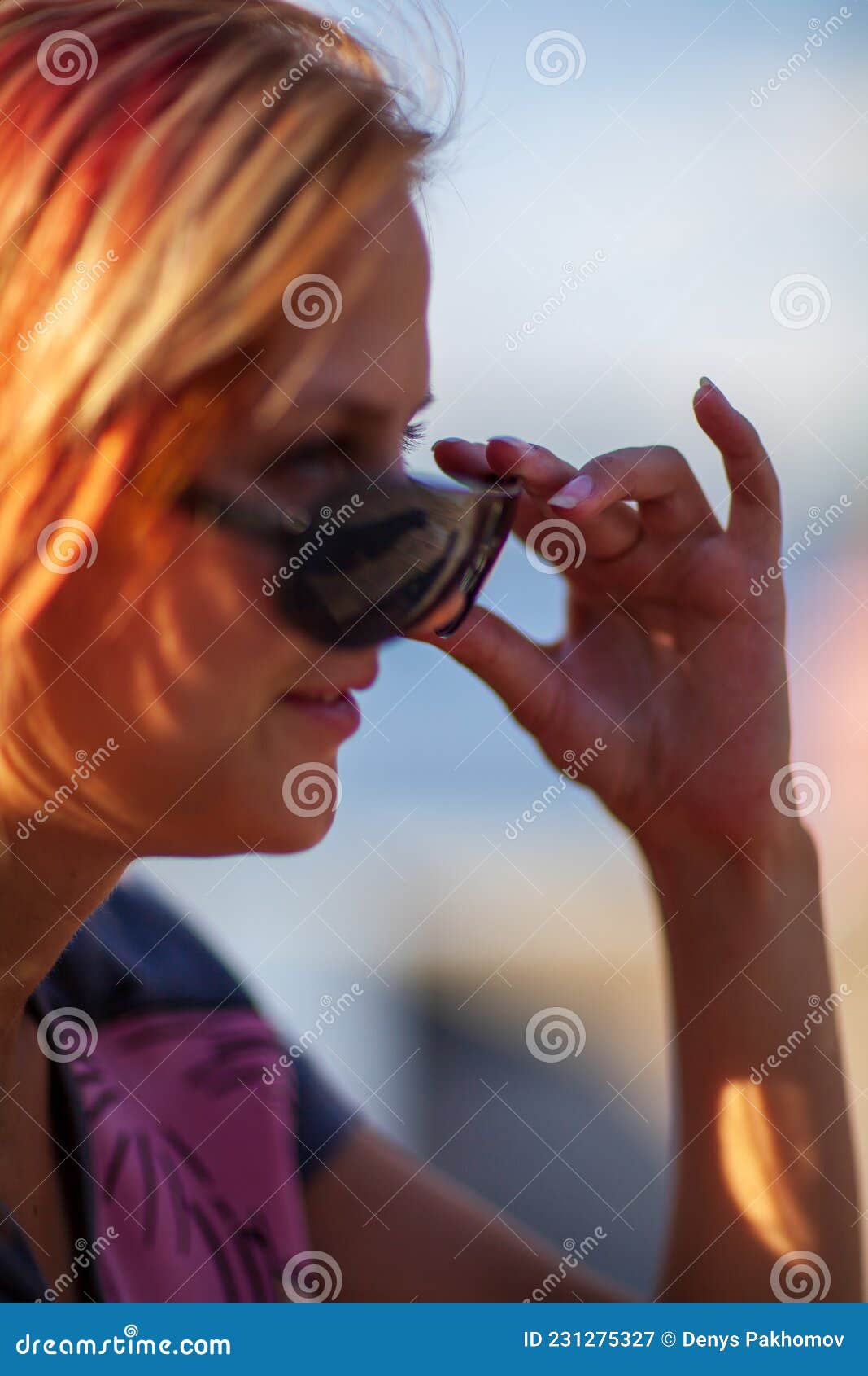 young blonde happy girl resting in the park on a warm summer day