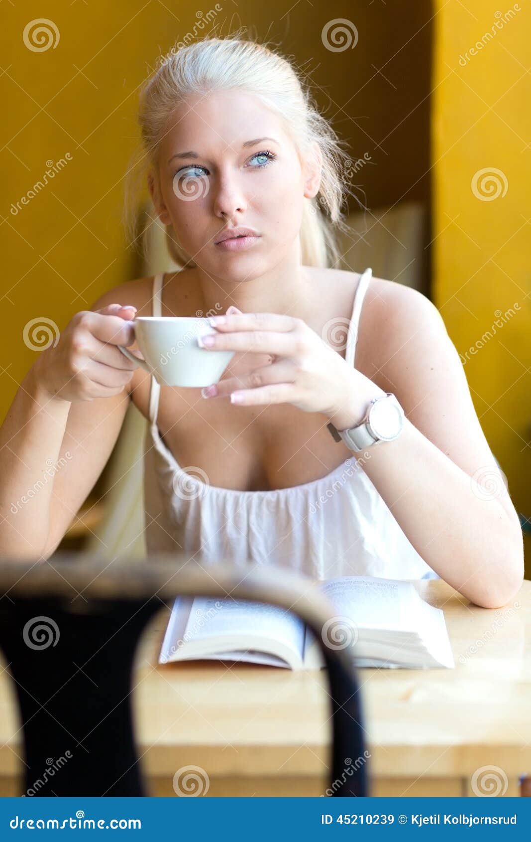 Young Blonde Woman Drinking Coffee At Cafe Sto