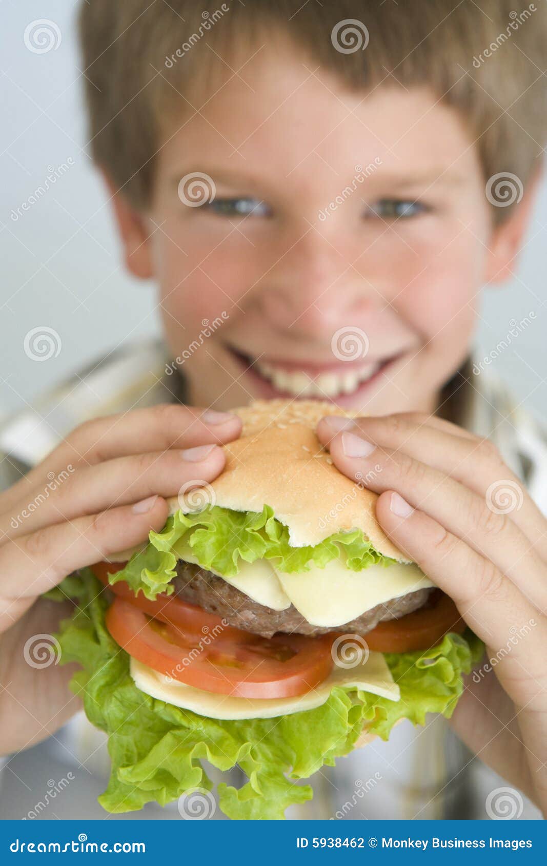 Young Boy Eating Cheeseburger Smiling Stock Photo Image of head