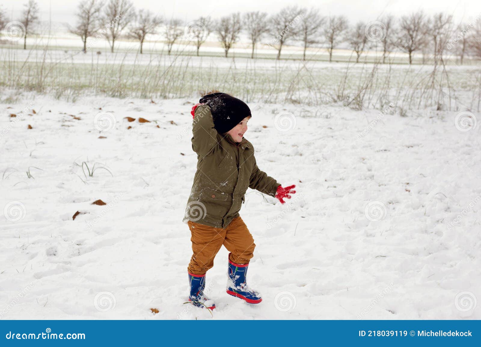 A Young Boy Playing in the Snow, Throwing a Snowball Stock Image