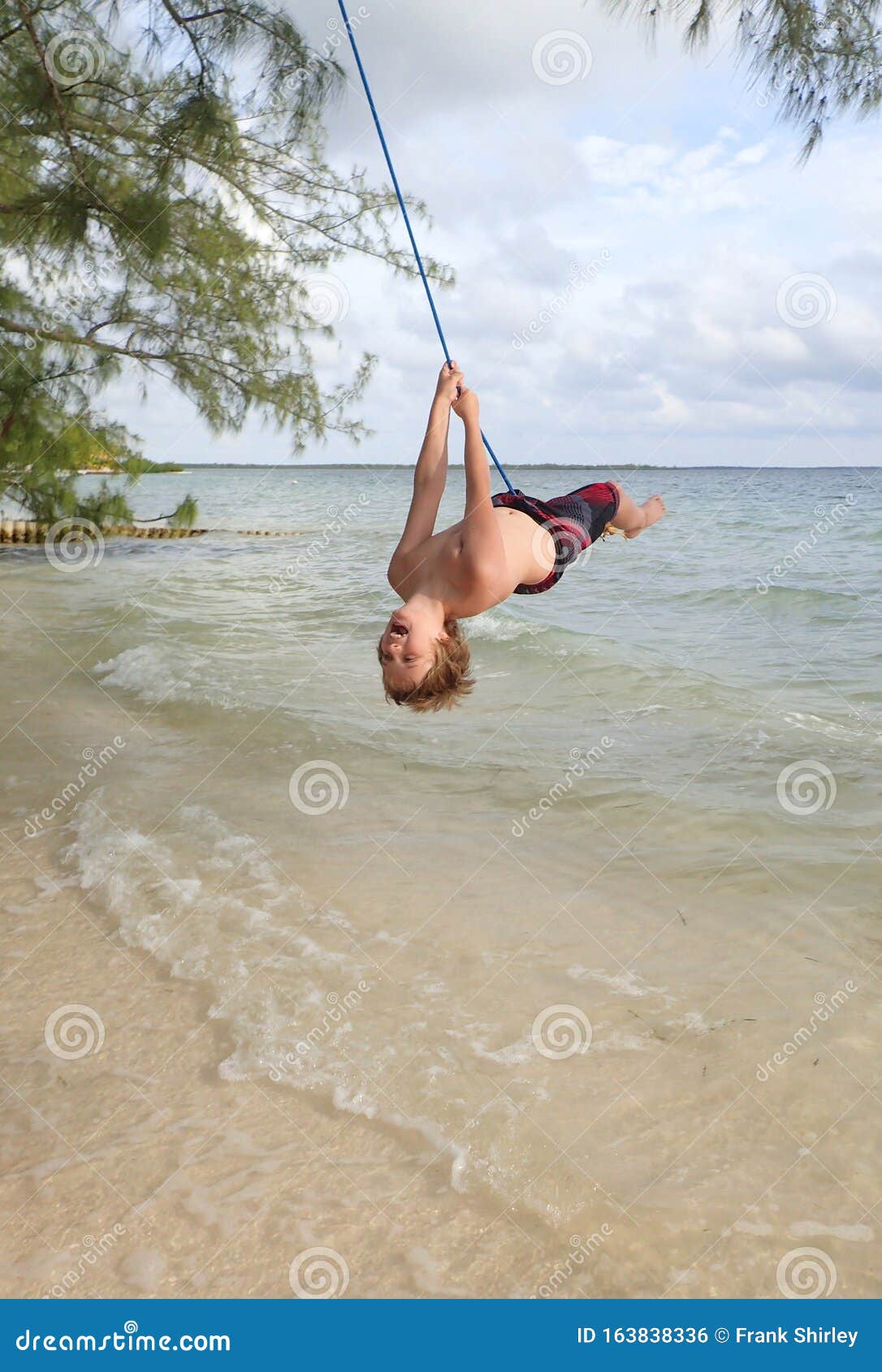 Young Boy on Rope Swing Over Ocean Water Stock Photo - Image of