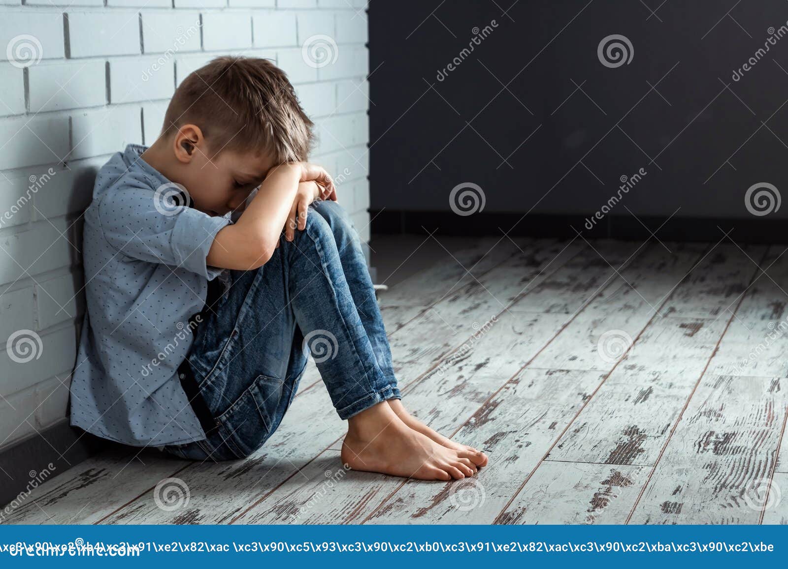 A Young Boy Sits Alone with a Sad Feeling at School Near the Wall ...
