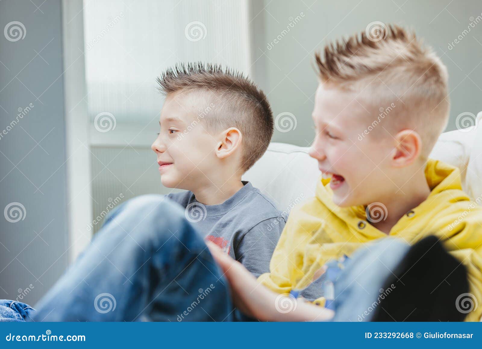 Young Boy Sitting on a Sofa with His Laughing Brother Stock Photo - Image  of hand, digital: 233292668