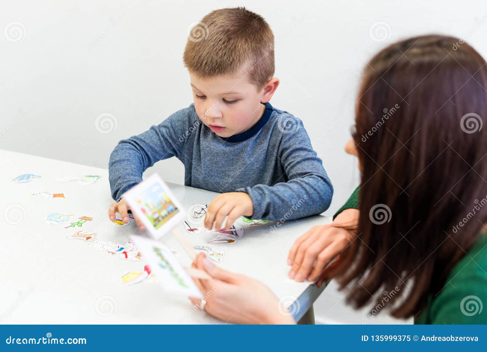 young boy in speech therapy office. preschooler exercising correct pronunciation with speech therapist. child occupational therapy