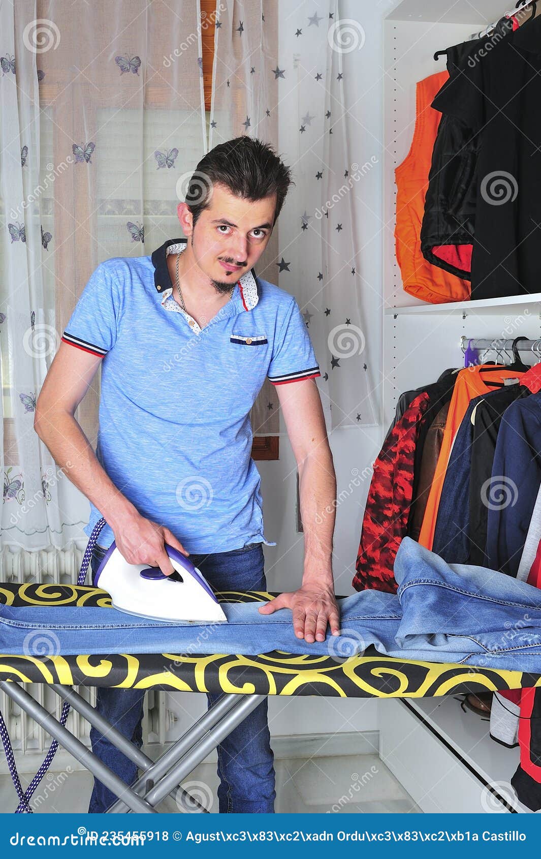 Young Boy Steam Ironing Some Jeans. Stock Photo Image of indoors