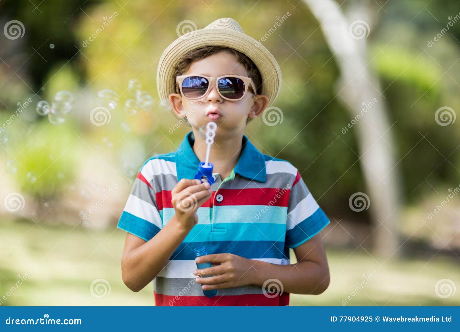 Young Boy in Sunglasses Blowing Bubbles through Bubble Wand Stock Image