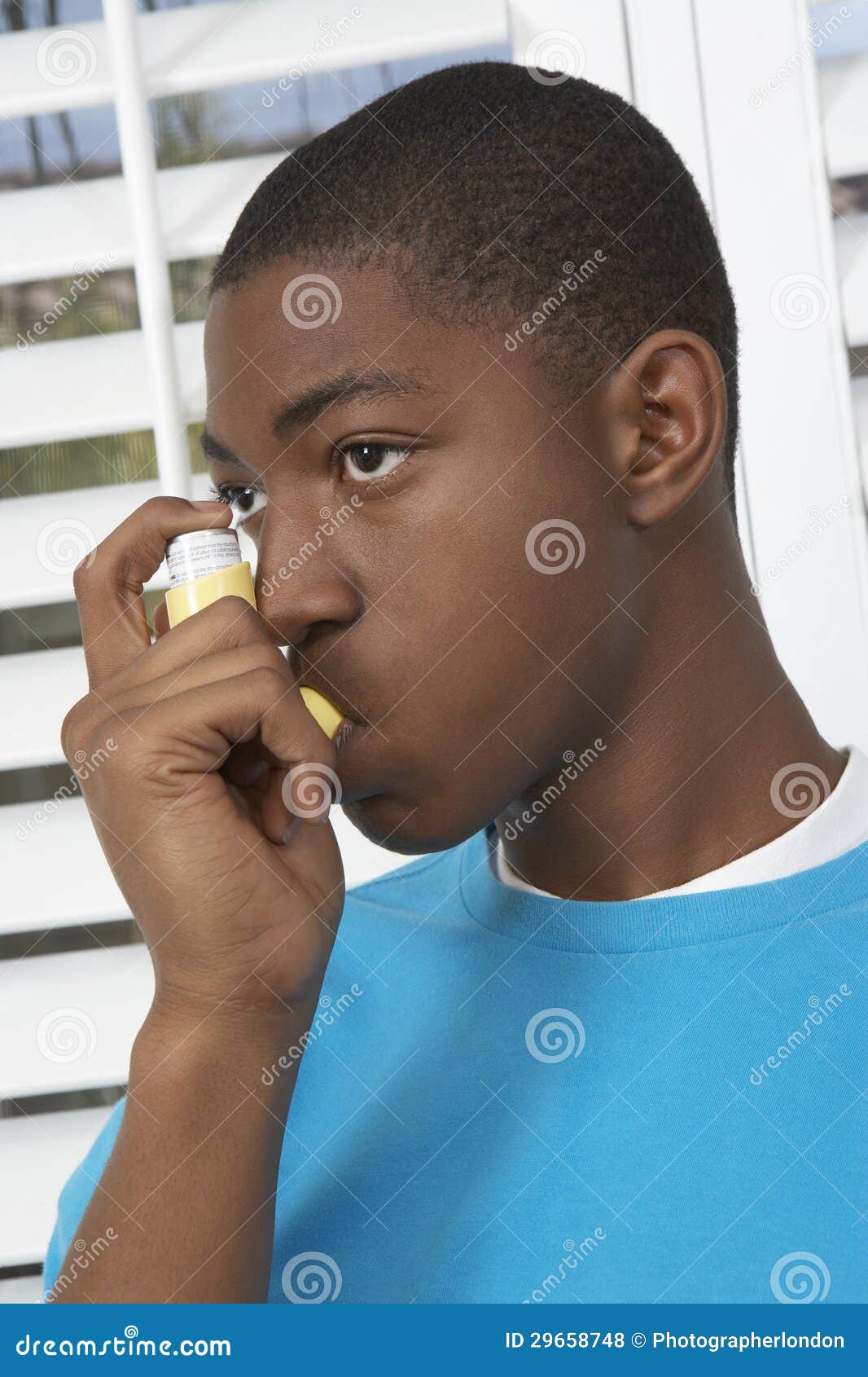 young boy using asthma inhaler