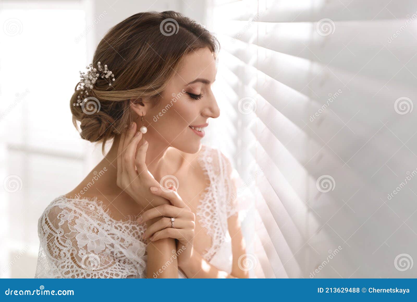 Young Bride with Elegant Wedding Hairstyle Near Window Indoors Stock