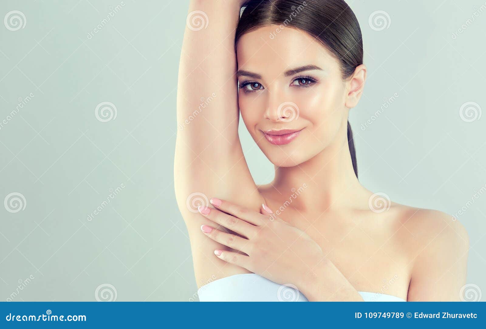 portrait of young woman with clean fresh skin and soft, delicate make up. woman is touching to own armpit tenderly.