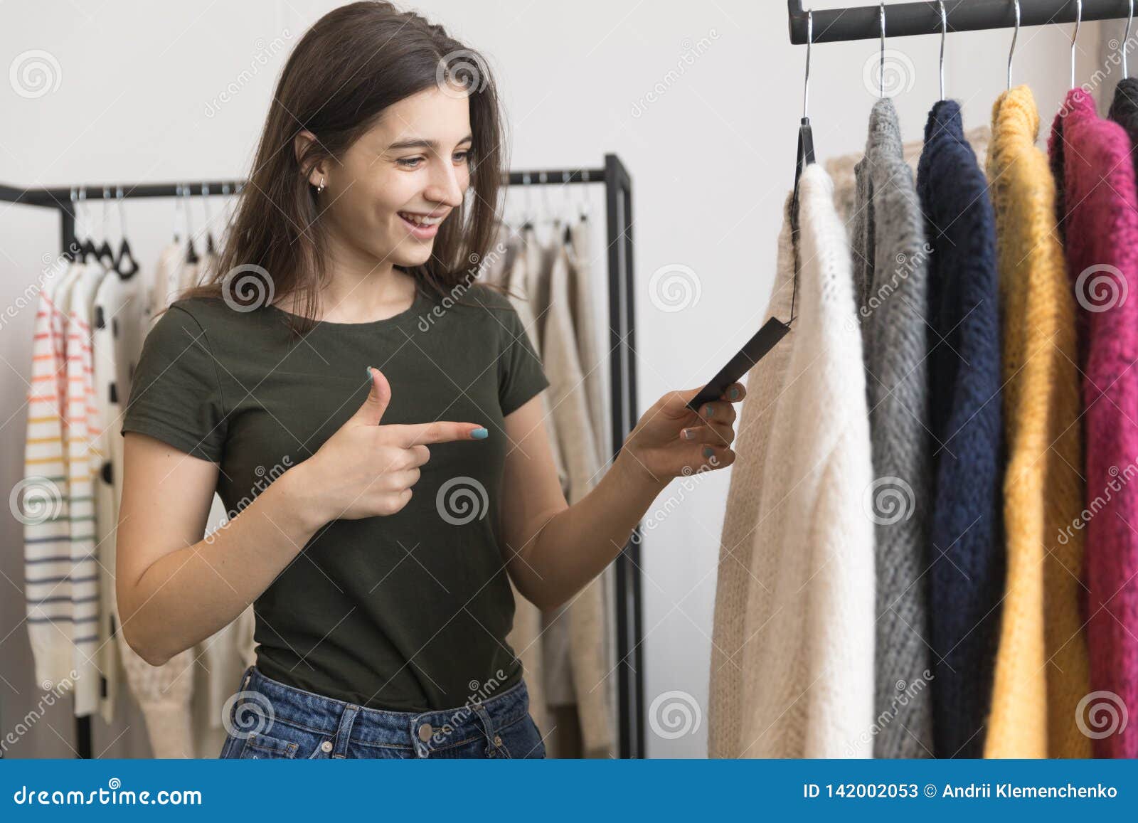 A Young Girl in a Clothing Store, Chooses a Sweater. Stock Image ...