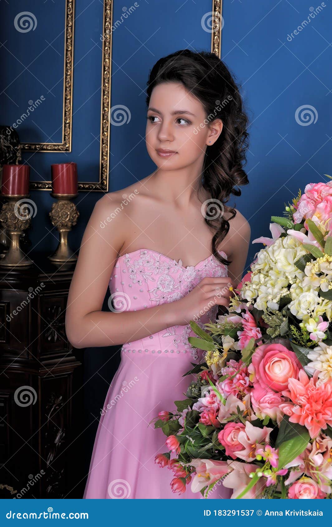 Brunette Girl In A Pink Elegant Dress Among The Flowers In The Room Stock Image Image Of 