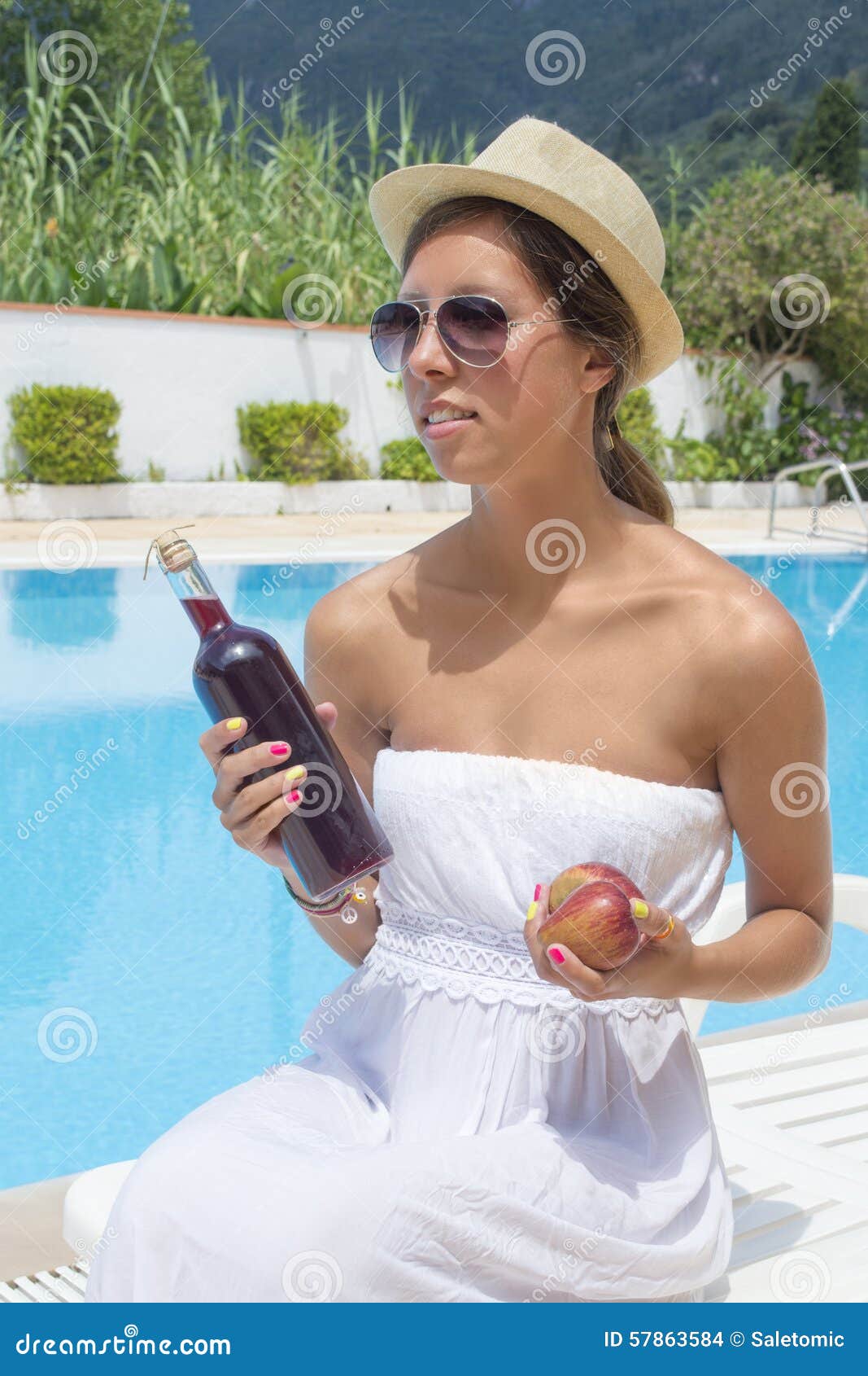 Young Brunette Girl In White Dress Holding Bottle Of Wine And An Stock