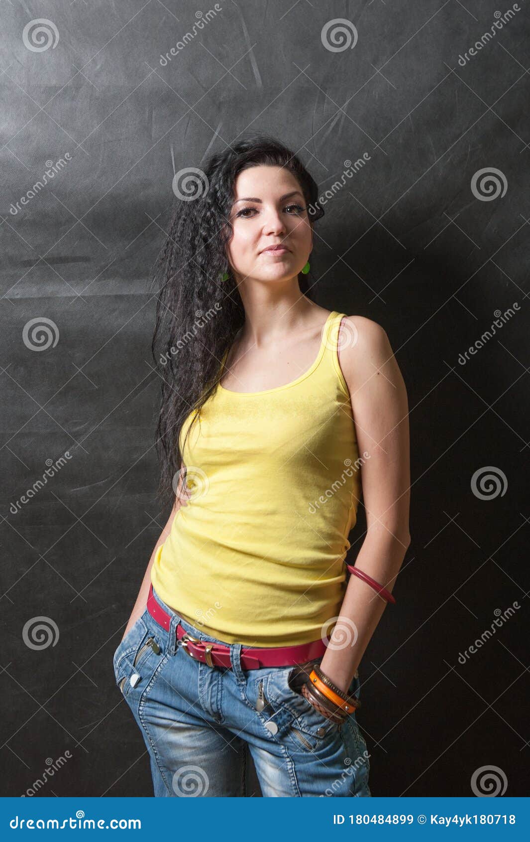 Young Brunette Girl In A Yellow T-shirt Against A Dark Background Stock ...