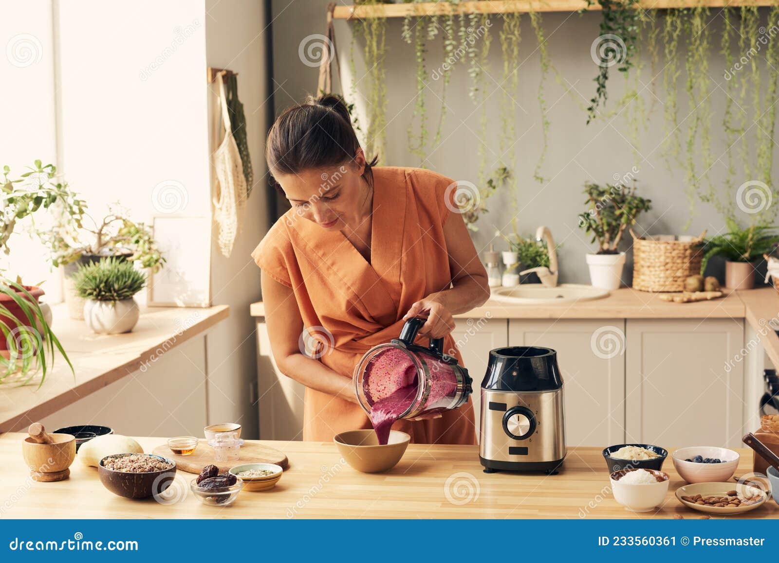 https://thumbs.dreamstime.com/z/young-brunette-woman-bending-over-kitchen-table-pouring-fresh-homemade-vegetable-smoothie-bowl-young-brunette-woman-233560361.jpg
