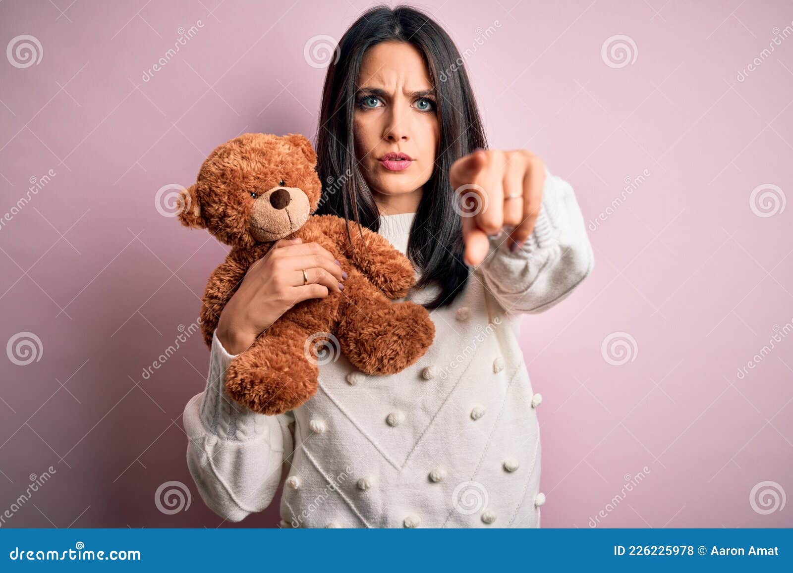 Young Brunette Woman with Blue Eyes Hugging Teddy Bear Stuffed Animal Over  Pink Background Pointing with Finger To the Camera and Stock Photo - Image  of animal, holding: 226225978