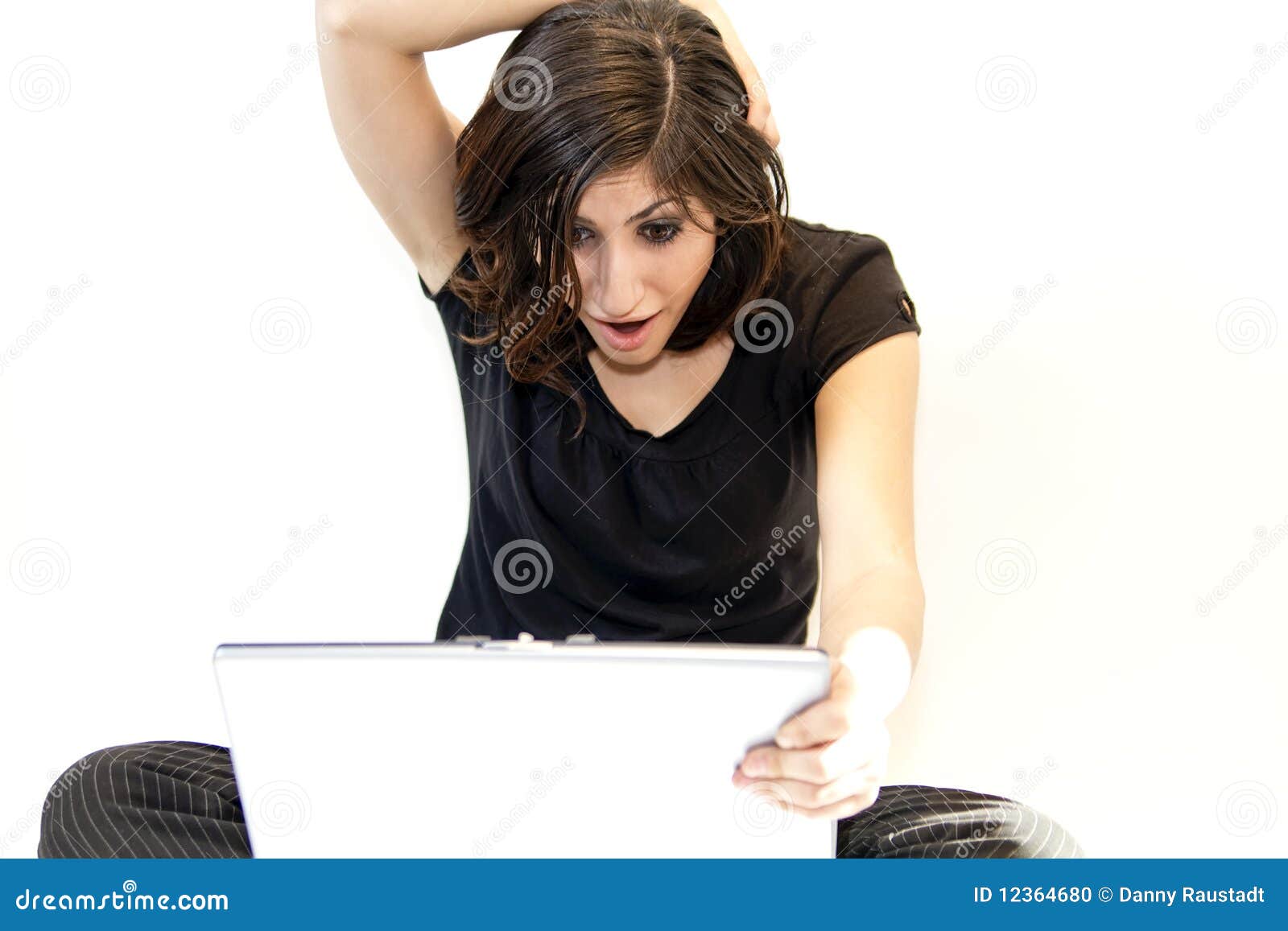 young brunette woman finds surprise on computer