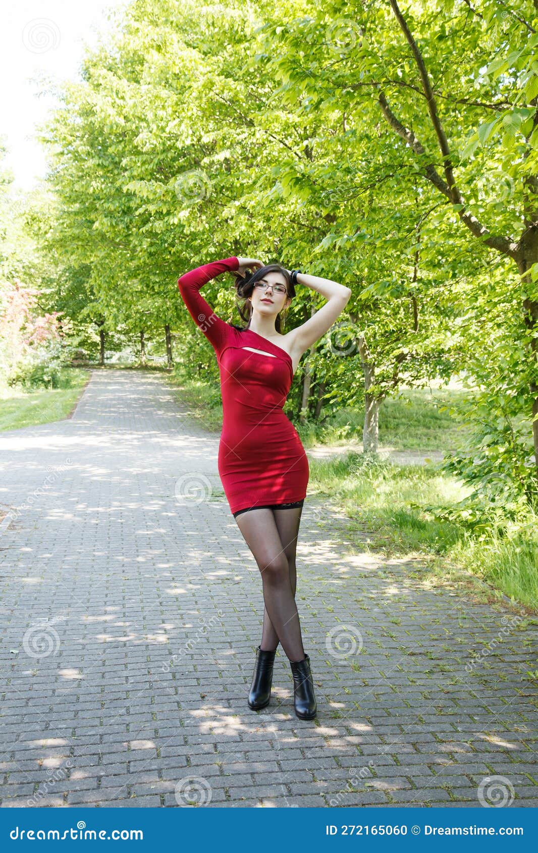 Young Brunette Woman in a Red Dress Standing on Alley in City Park in ...