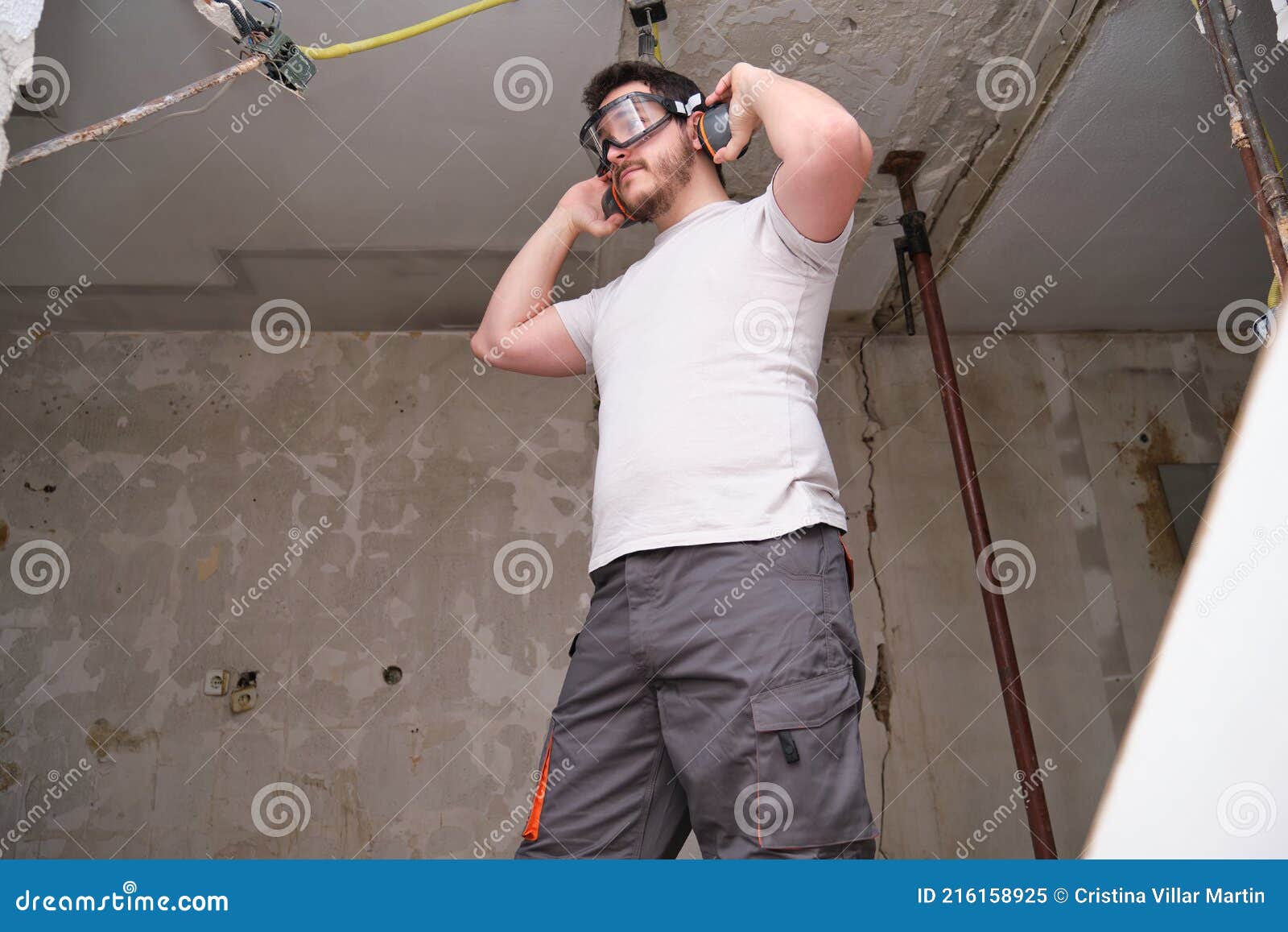 Young Builder Wearing Hearing Protection and Safety Glasses at a