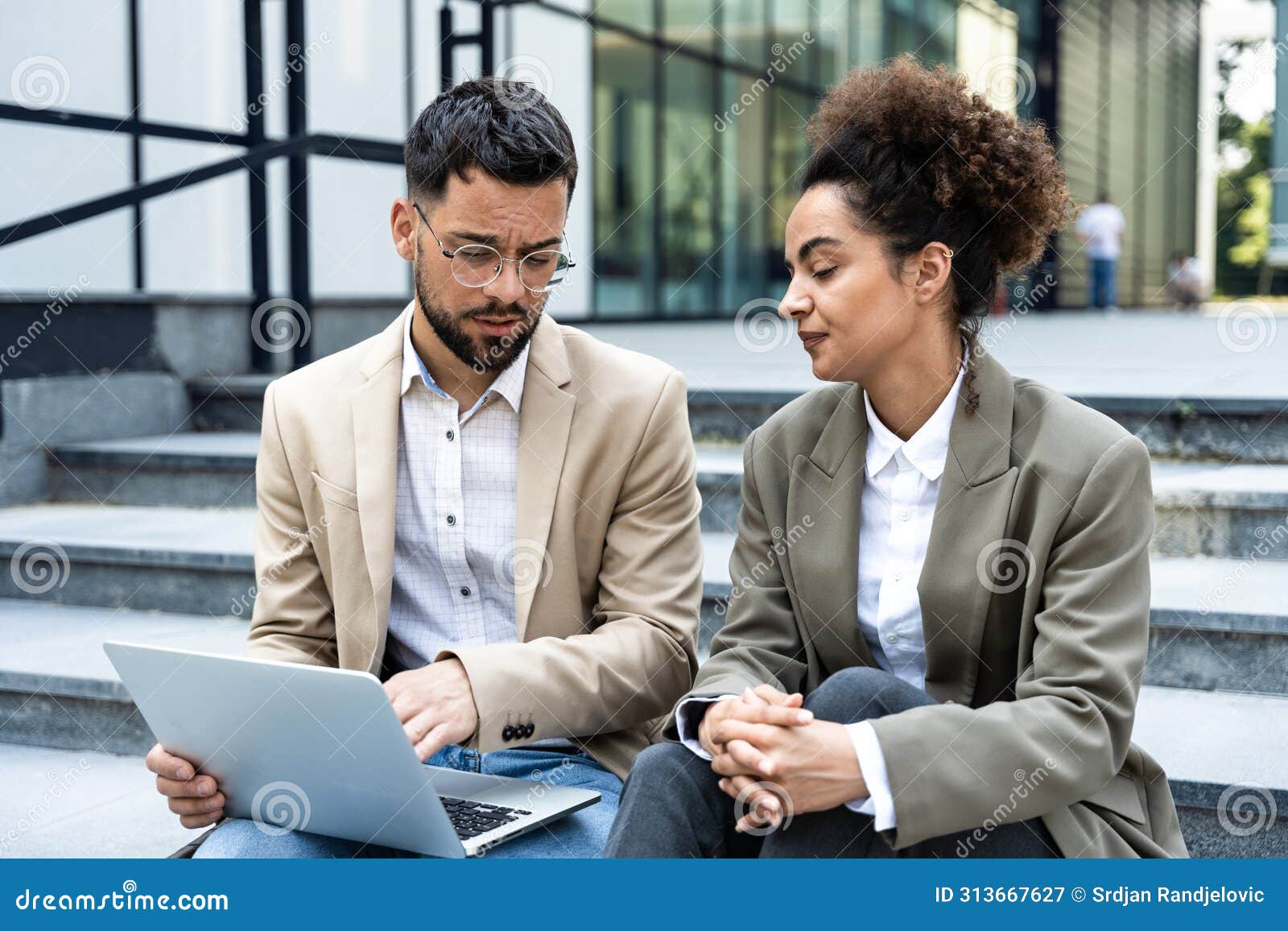 young business people fellow teamworkers sit on the stairs of the office building argue and cannot find a common solution to the