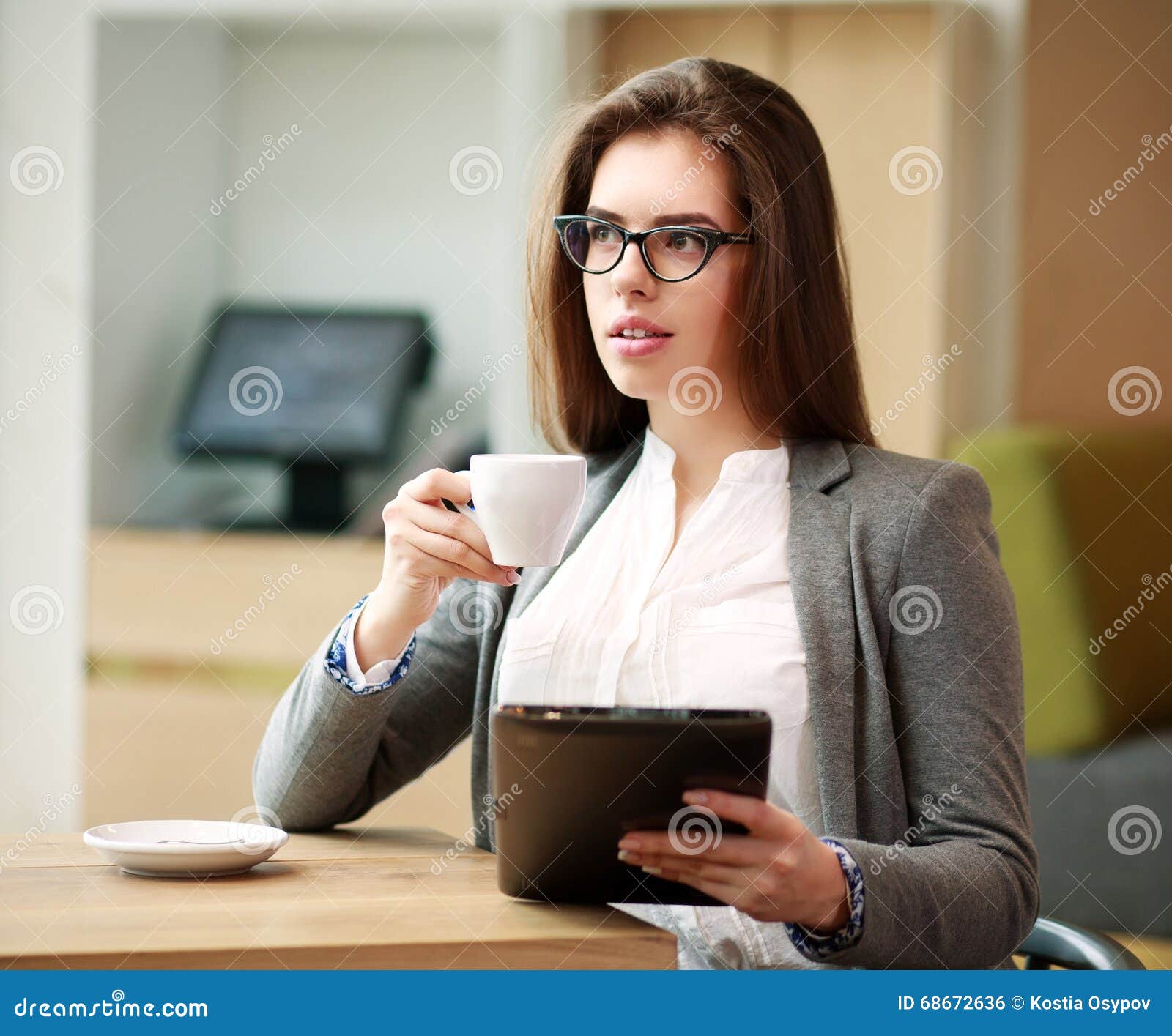 Young Business Woman with a Cup of Coffee Working in Office Stock Photo
