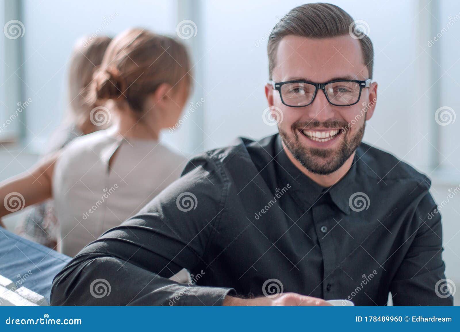 Young Businessman with a Cup of Coffee Sitting in a Modern Office ...