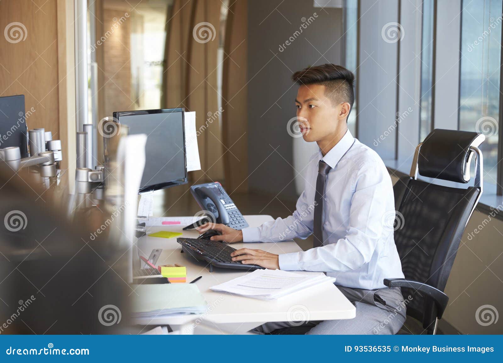 Young Businessman Sitting at Desk in Office Using Computer Stock Image