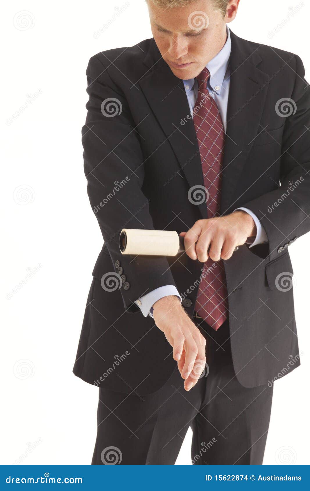 young businessman using lint brush