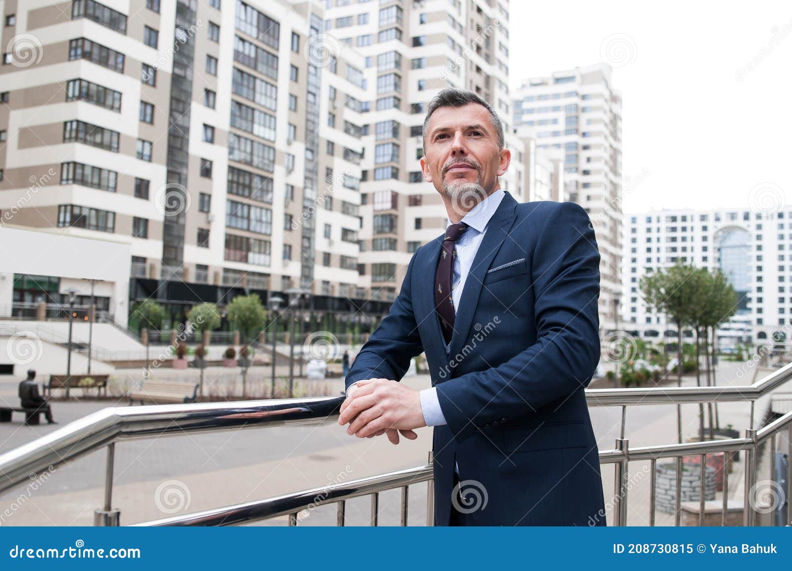 young businessman using smartphone in the urban environment. the man in suit full length