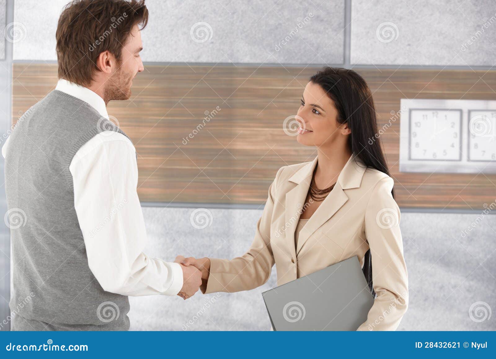 young businesspeople shaking hands smiling