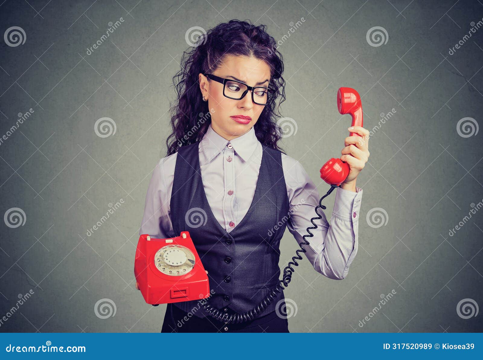 young business woman looking at a red phone with a suspicious expression