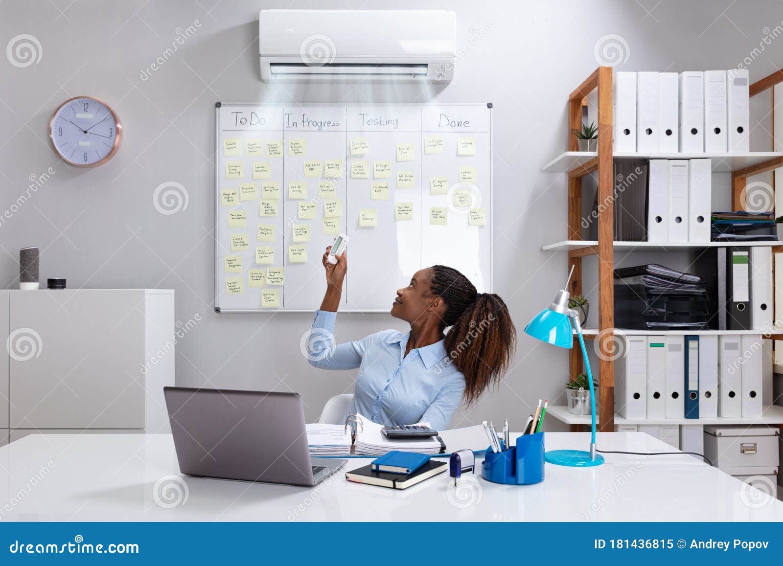 Businesswoman Operating Air Conditioner in Office Stock Image - Image of  happy, heating: 181436815