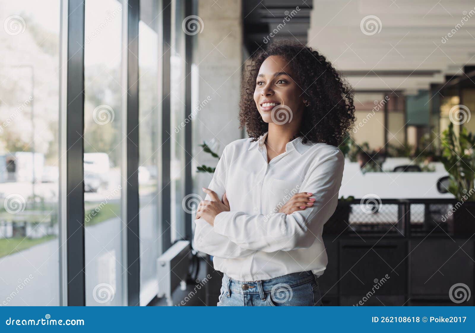 young businesswoman portrait, self confident young woman with crossed arms at office, people candid portraits