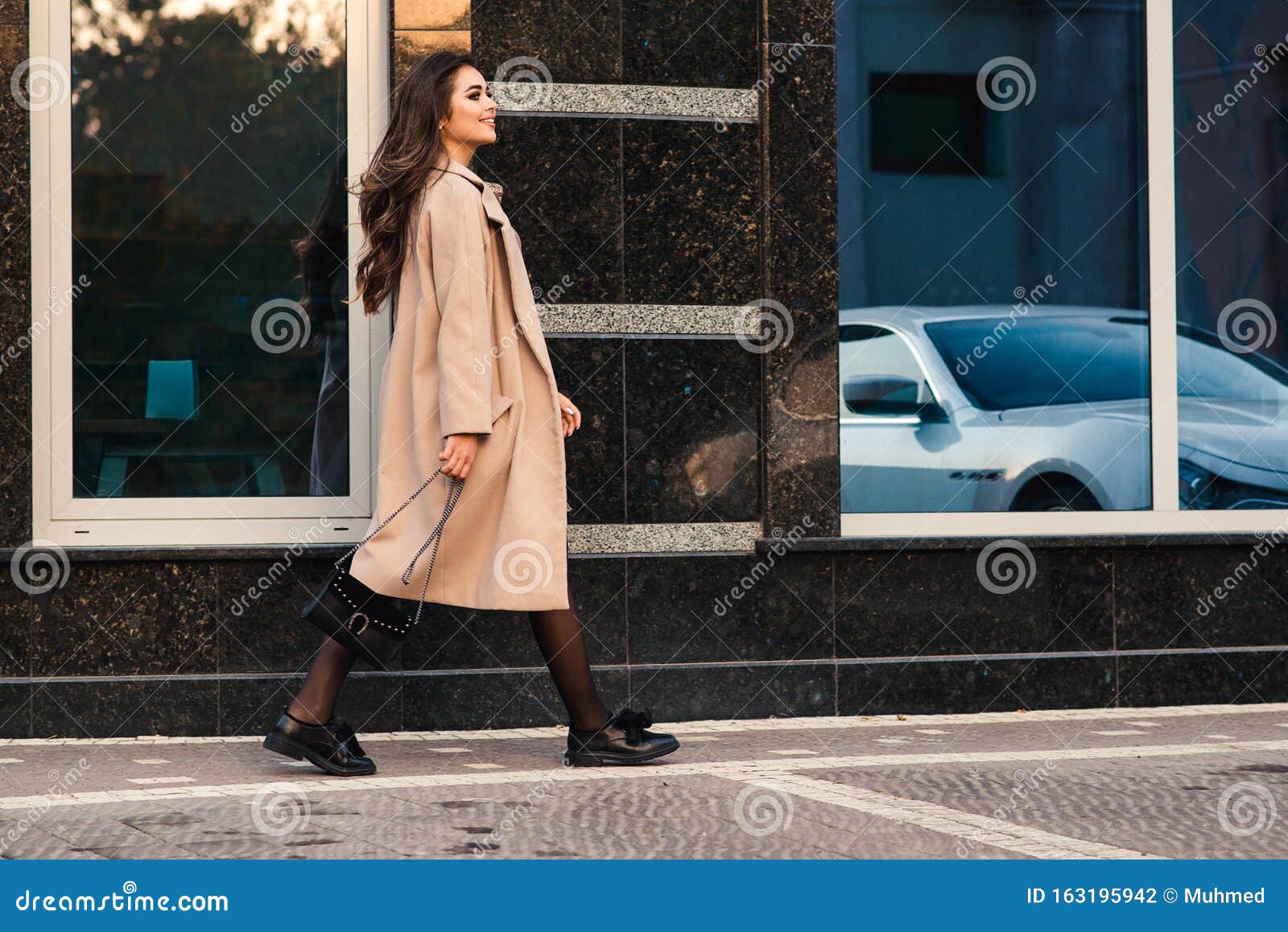 Young Businesswoman Walking on City Street in Front of Modern Wall ...