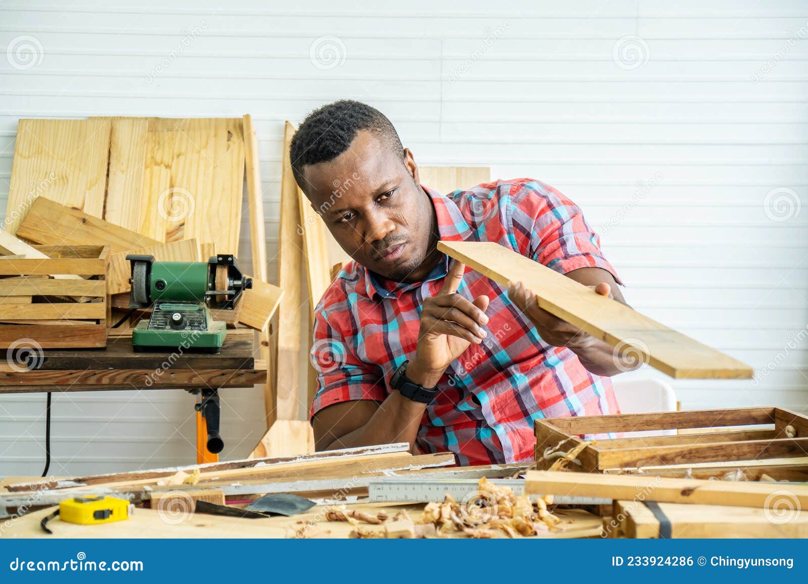 Young carpenter african american man looking and choosing wood and using  sandpaper to rub wooden plank at workshop table in carpenter wood factory  7424164 Stock Photo at Vecteezy