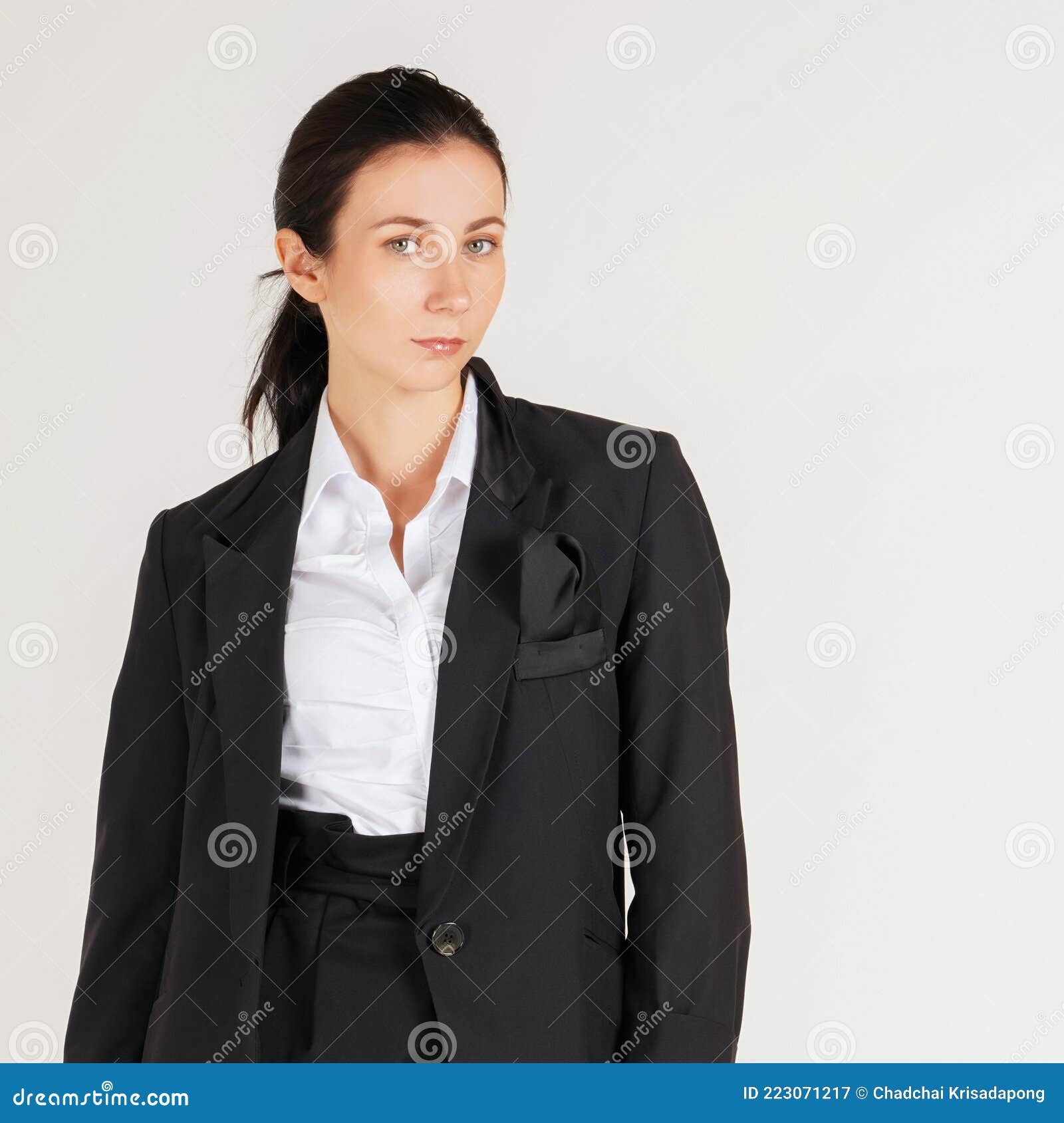 young cauasian business woman in white shirt and  black suit standing in a white photography scene. portrait on white background