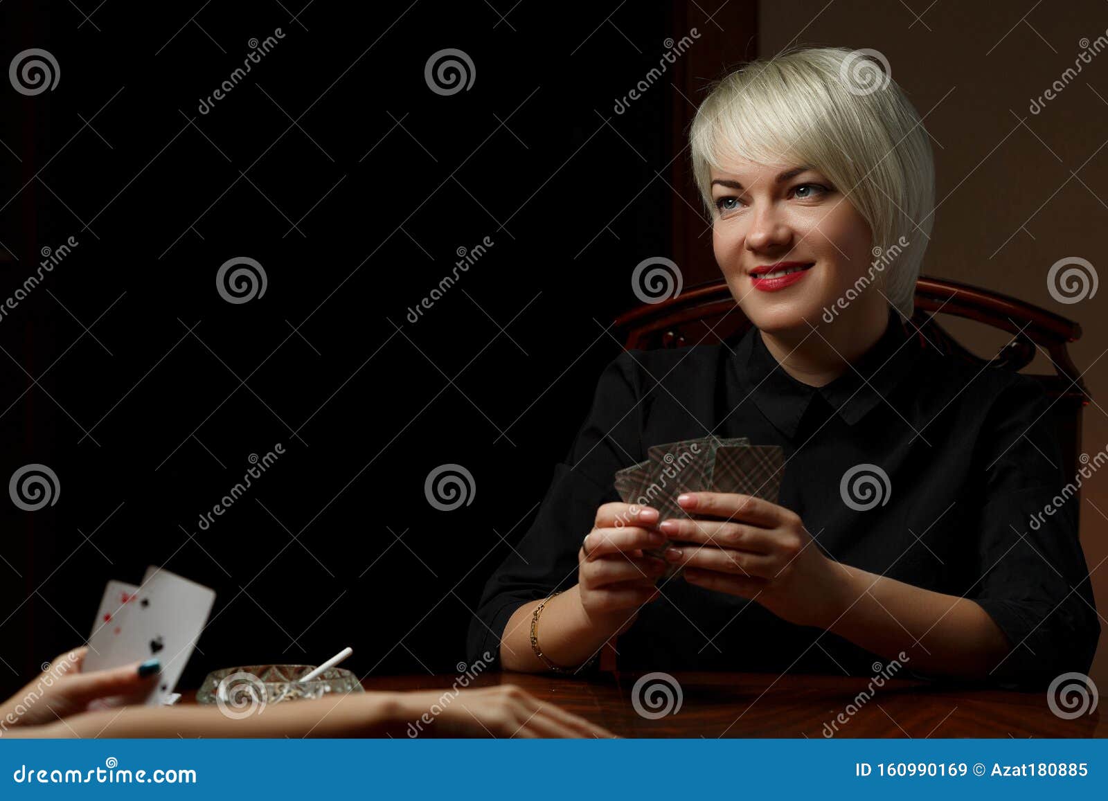 A Young Caucasian Blonde in Black Clothes is Sitting at a Table and ...