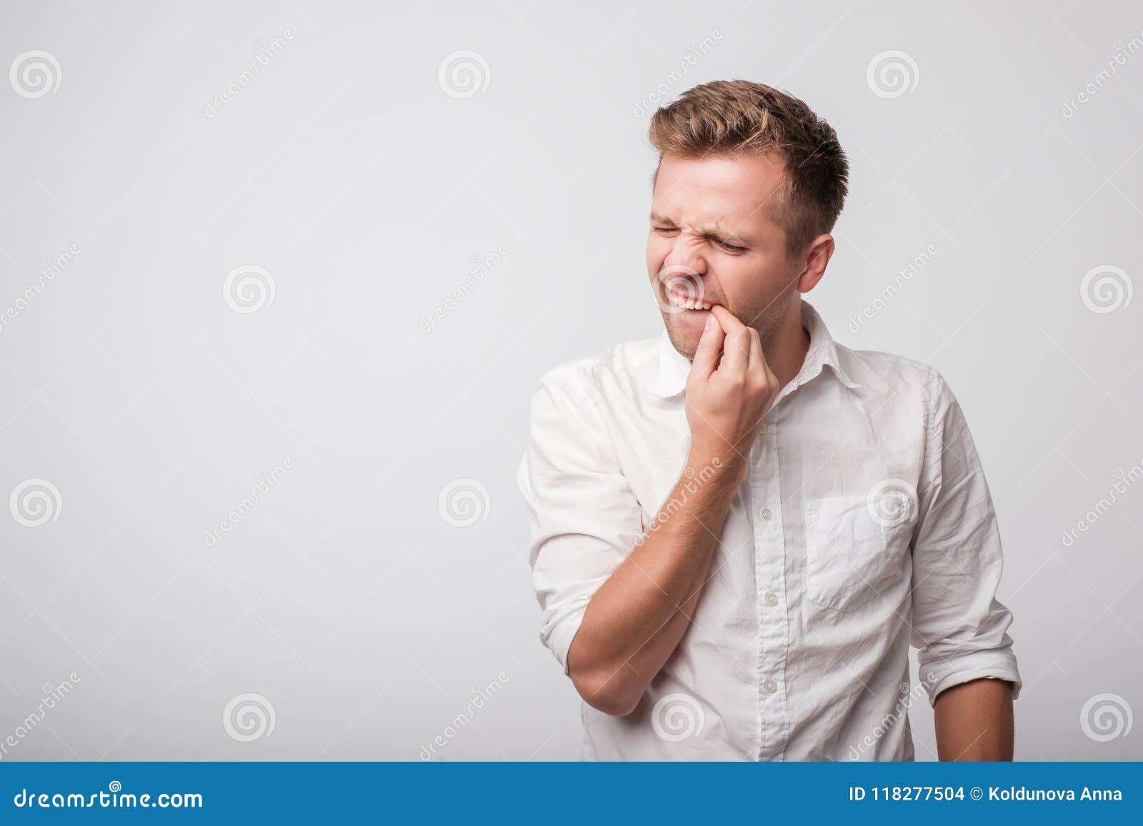 Young Caucasian Guy in White Shirt Trying To Clean Teeth with Nail ...
